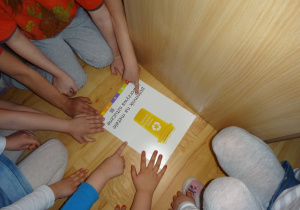 Dzieci wskazują pojemnik na plastik.